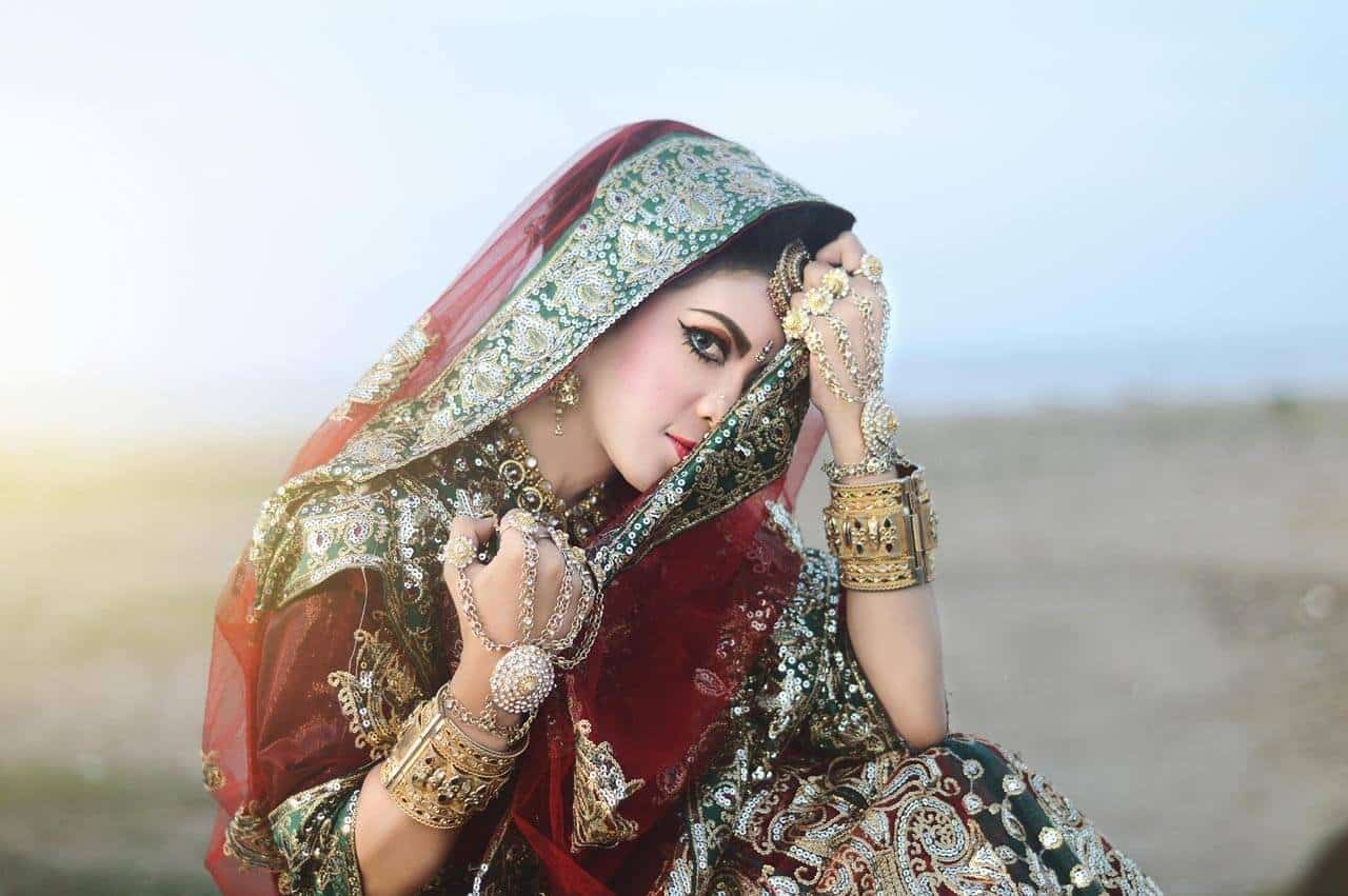 Mulher em traje tradicional com joias detalhadas.