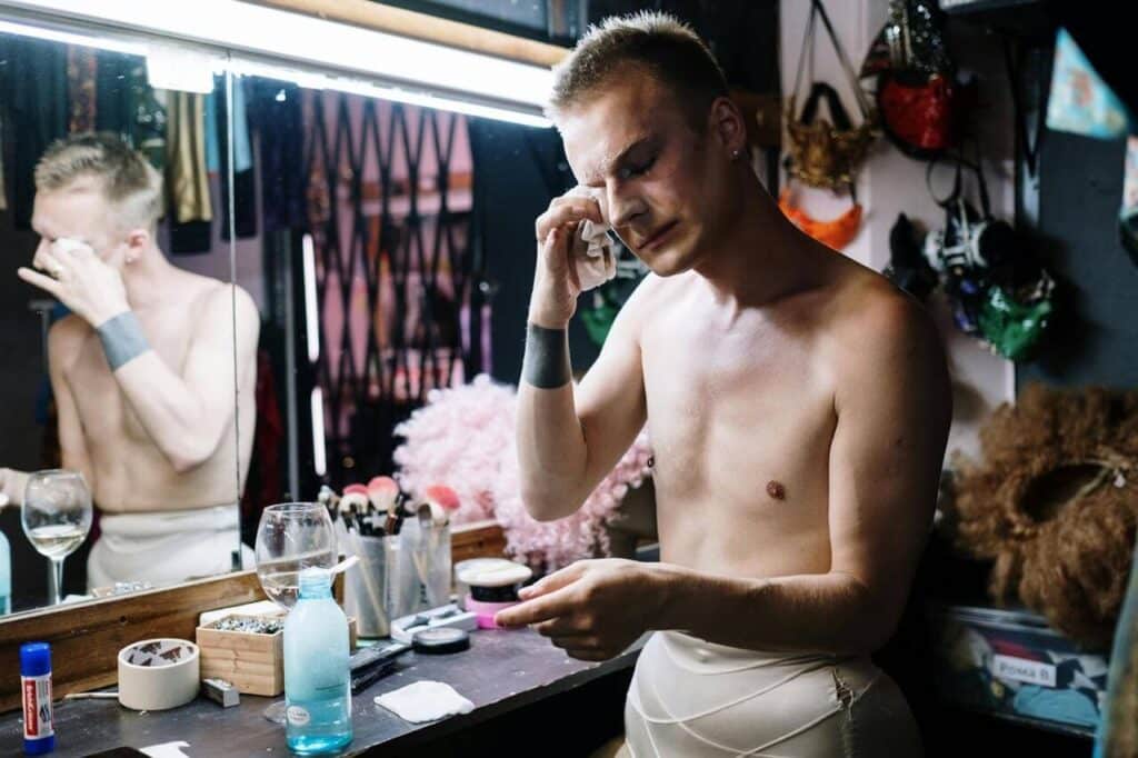 Artista removendo maquiagem no camarim