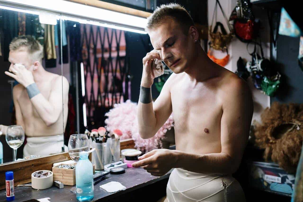 Artista removendo maquiagem no camarim