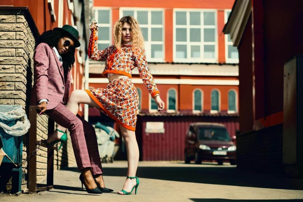 Modelos posando na cidade com roupas coloridas.