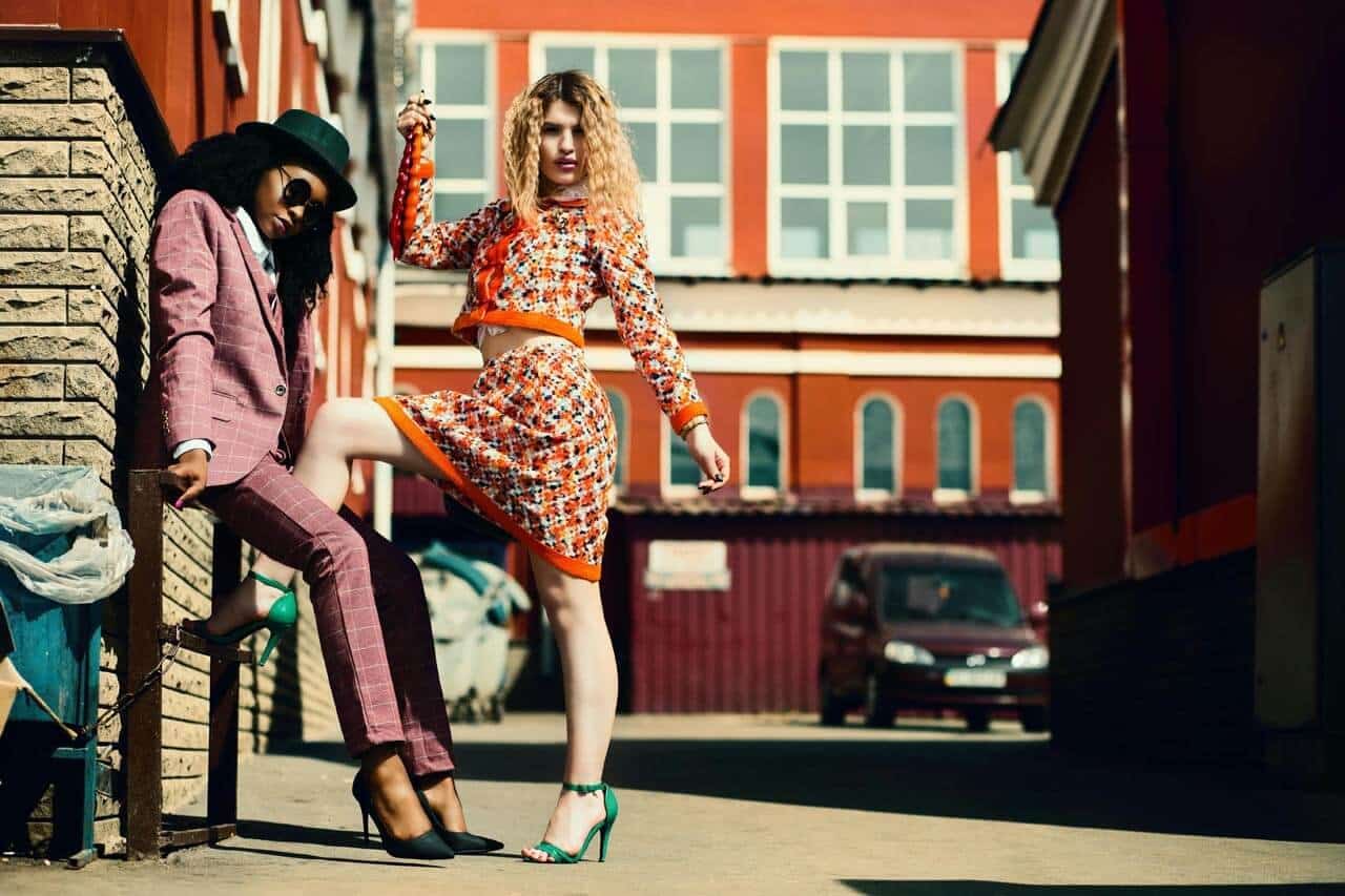 Modelos posando na cidade com roupas coloridas.
