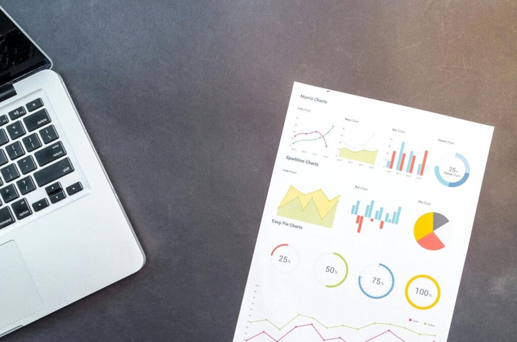 Laptop e folha com gráficos e dados