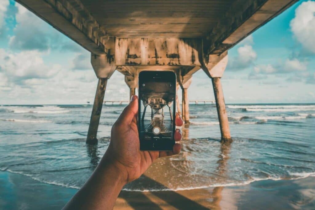 Foto de celular sob ponte sobre o mar