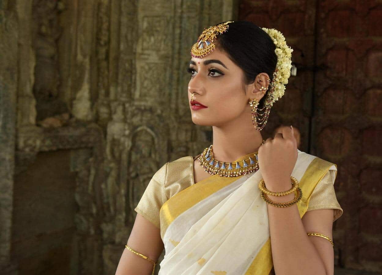 Mulher indiana em traje tradicional com joias elegantes.