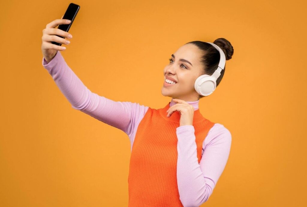 Pessoa tirando selfie, usando fones de ouvido
