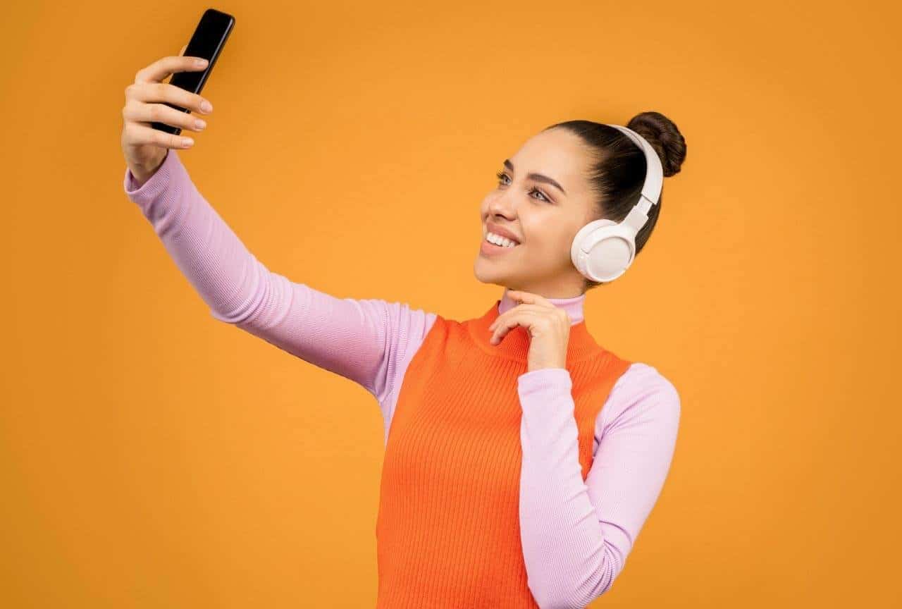Pessoa tirando selfie, usando fones de ouvido
