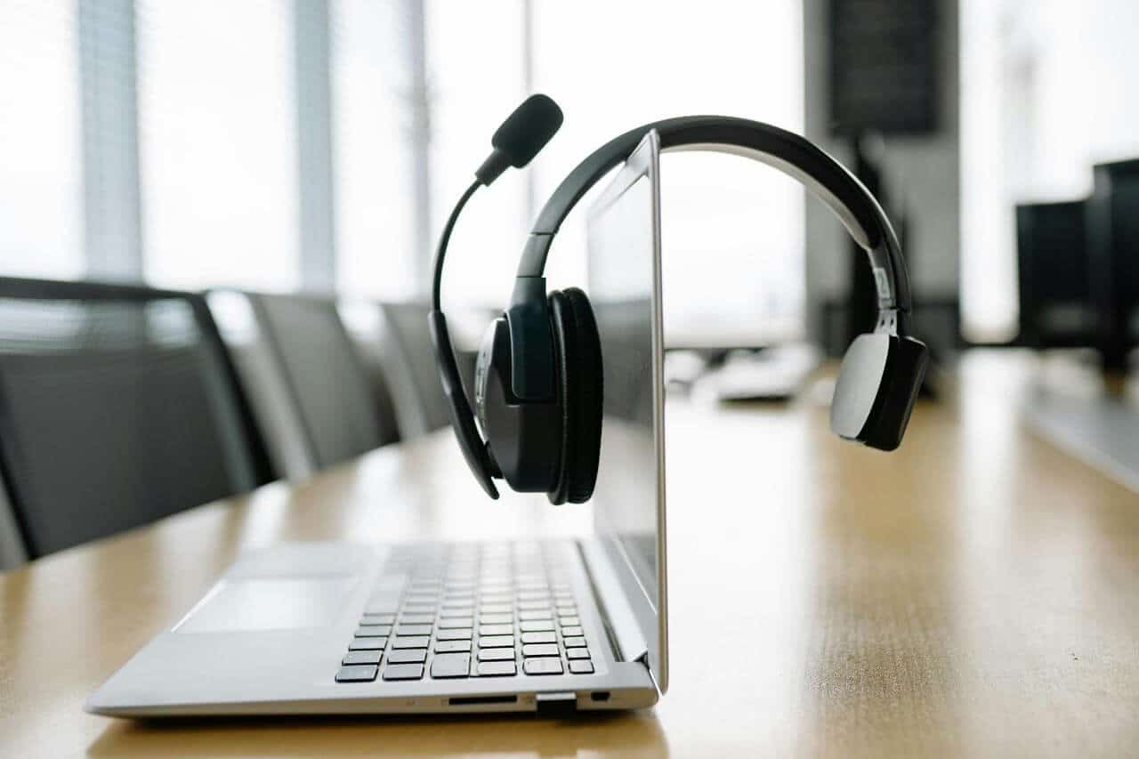 Notebook com headset em sala de reunião moderna.