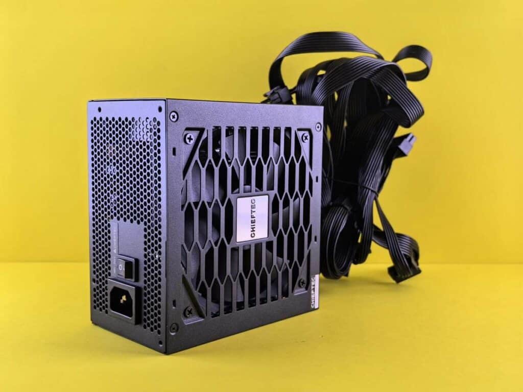 Fonte de alimentação de computador em fundo amarelo.