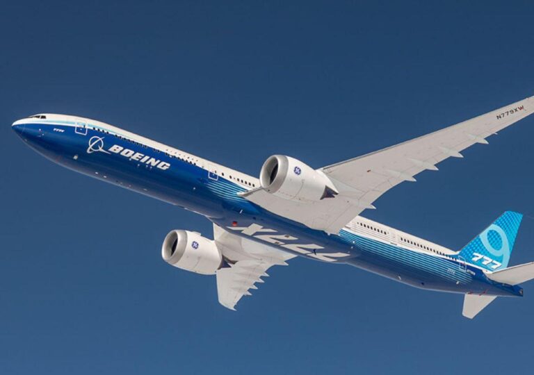 Avião Boeing 777X voando no céu azul.