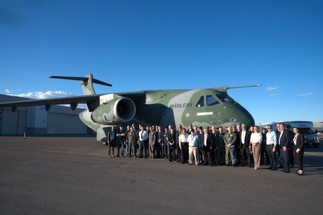 Avião militar brasileiro com grupo de pessoas ao lado.