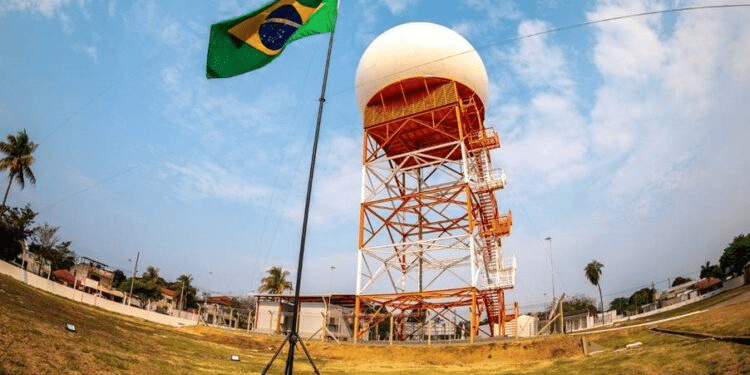 Radar meteorológico com bandeira do Brasil ao lado.