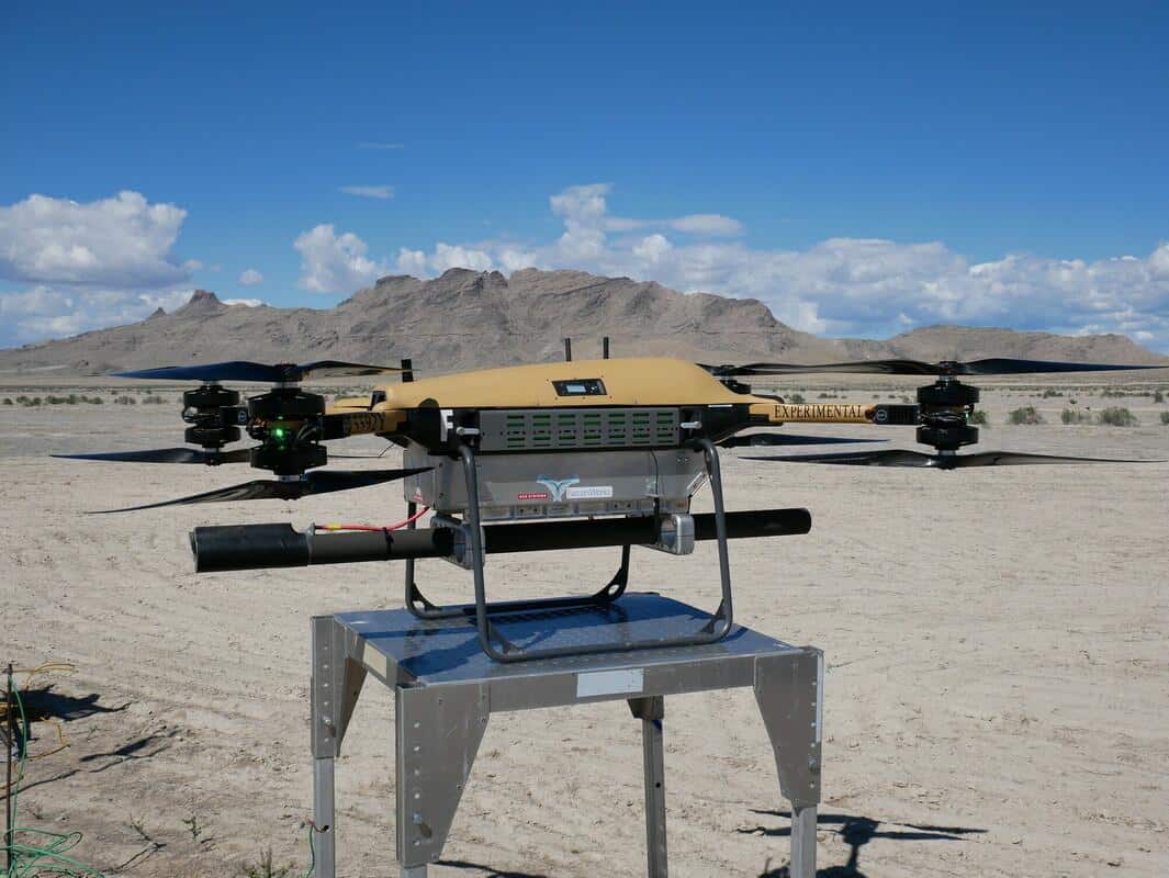 Drone experimental em deserto com montanhas ao fundo.