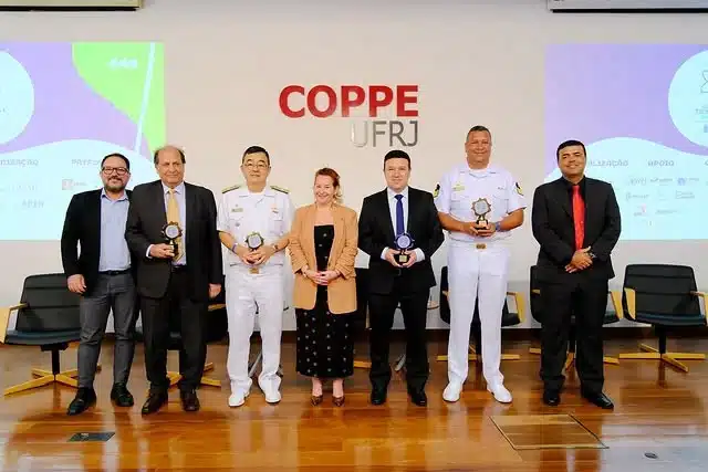 Pessoas posam com troféus na cerimônia COPPE UFRJ.