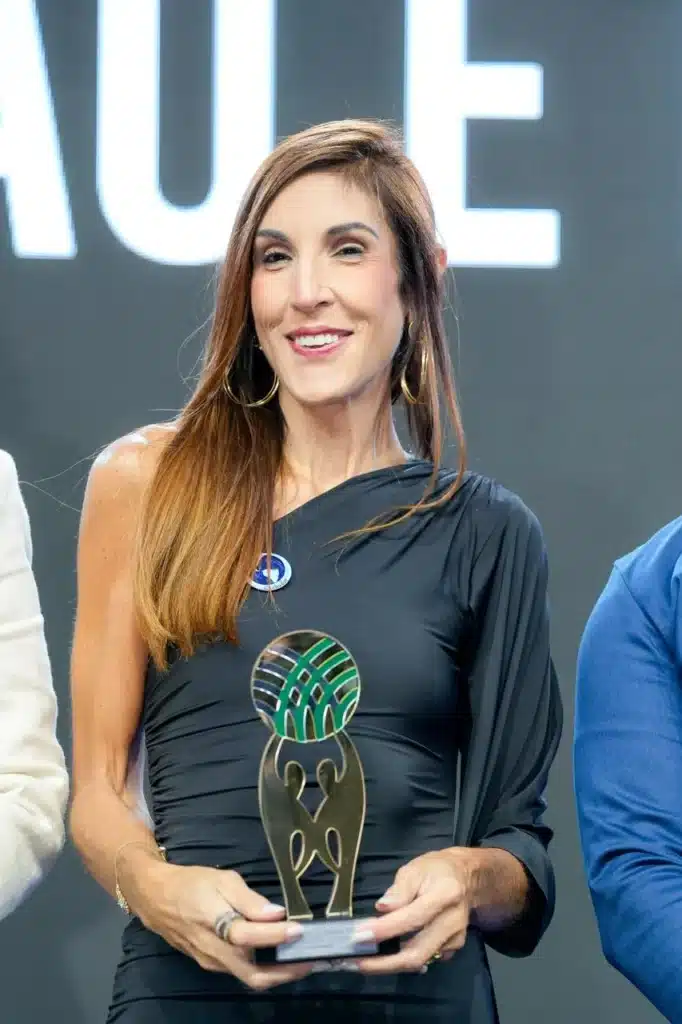 Pessoa segurando troféu em evento.