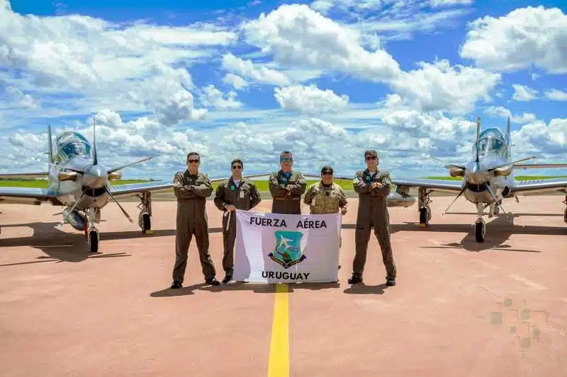 Pilotos uruguaios posando com aviões militares.