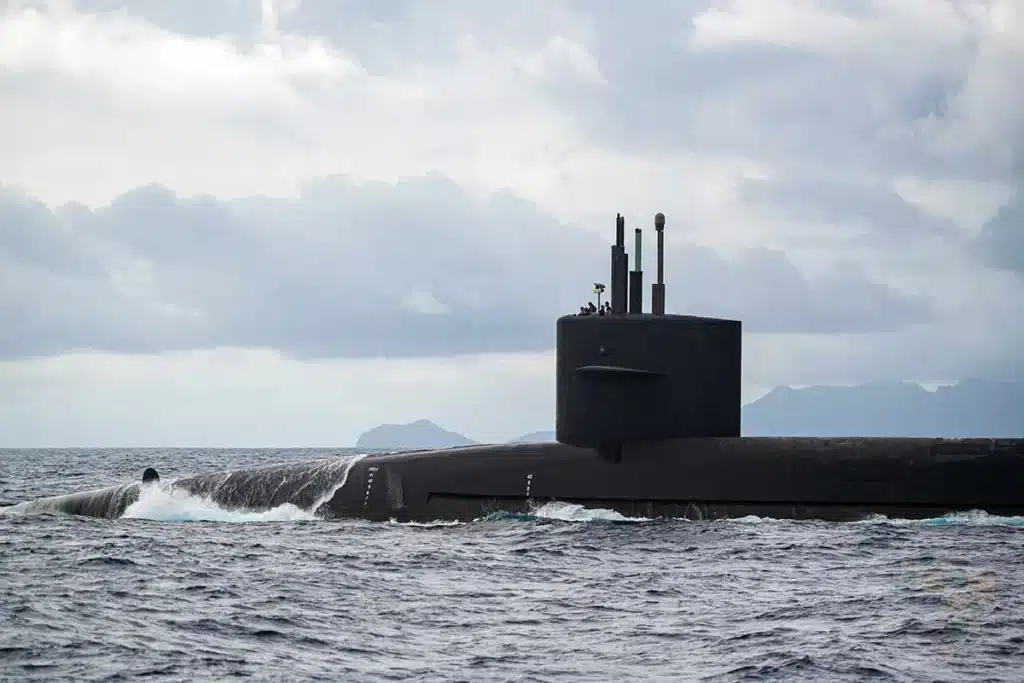 Submarino navegando em mar aberto sob céu nublado.
