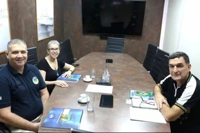 Três pessoas em reunião no escritório.