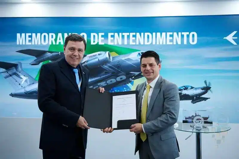 Dois homens seguram documento de memorando de entendimento.
