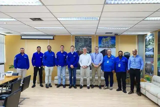 Equipe de homens reunidos em sala de reuniões.