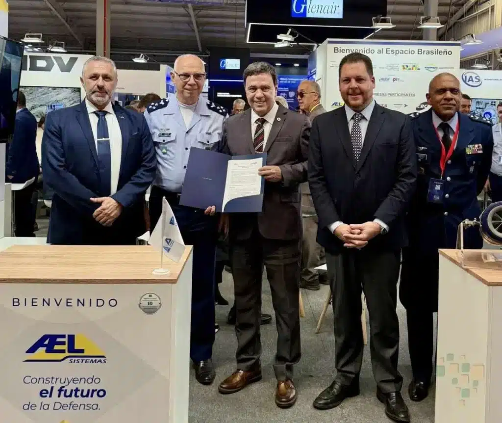 Executivos posam com documento em feira de defesa.