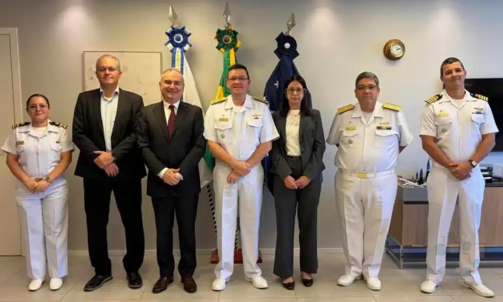 Grupo de oficiais e civis posando juntos.