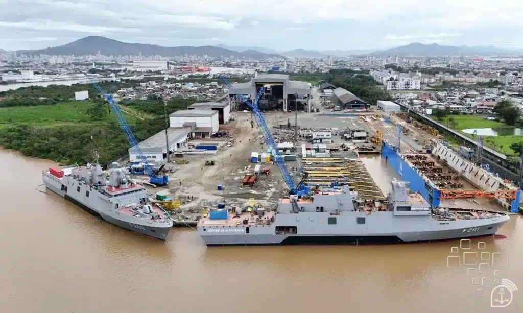Estaleiro com navios ancorados em rio.