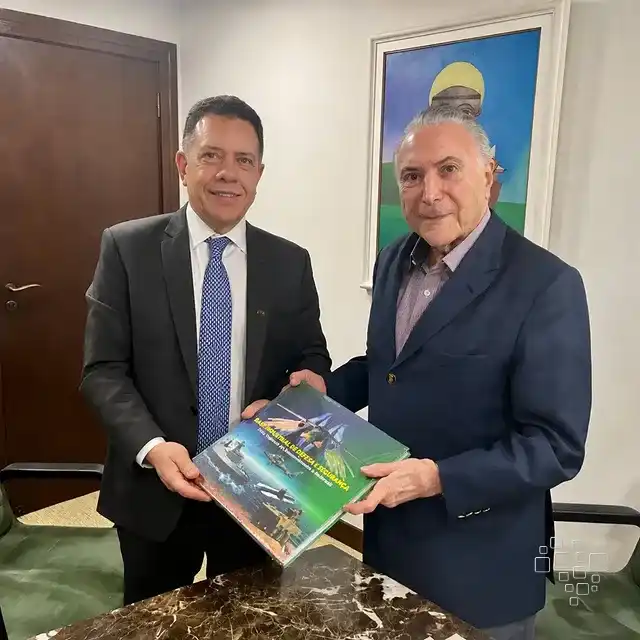 Dois homens em escritório com revista.