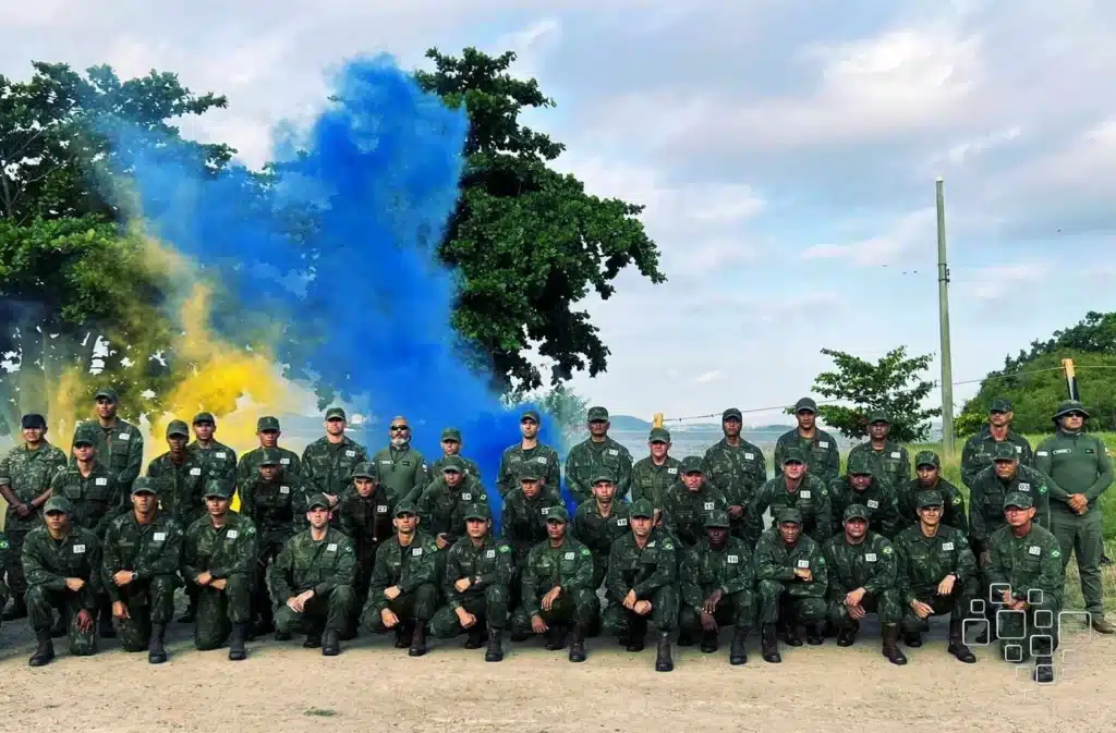 Soldados posando com fumaça azul e amarela ao fundo.