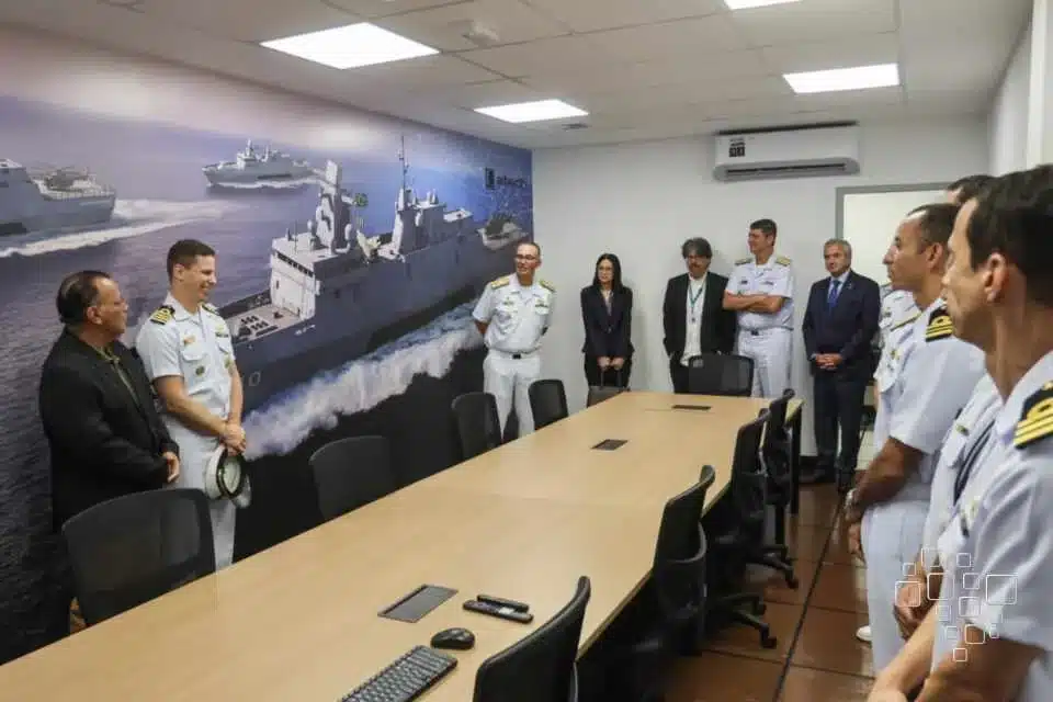 Reunião de oficiais da marinha em sala de conferências.