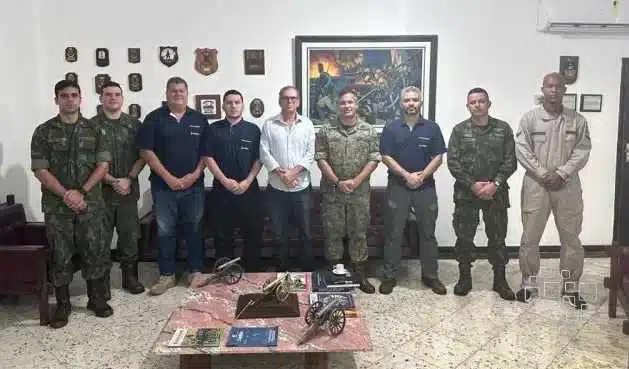 Grupo de homens em pé, incluindo militares.