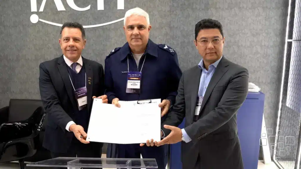 Três homens segurando documento em evento corporativo.