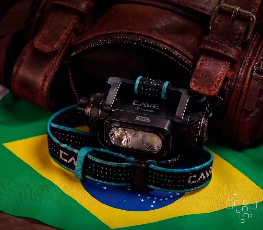 Lanterna de cabeça CAVE sobre bandeira do Brasil.