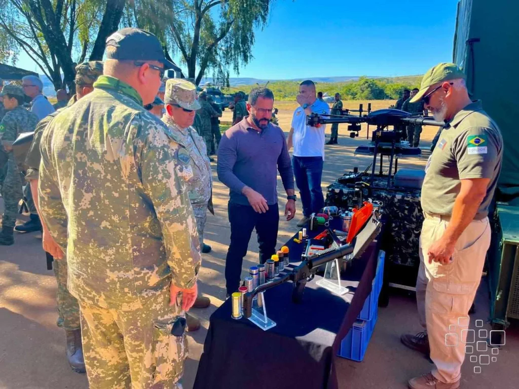 Militares observam mesa com equipamentos e drone.