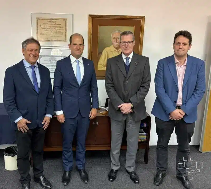 Quatro homens de terno em uma sala.