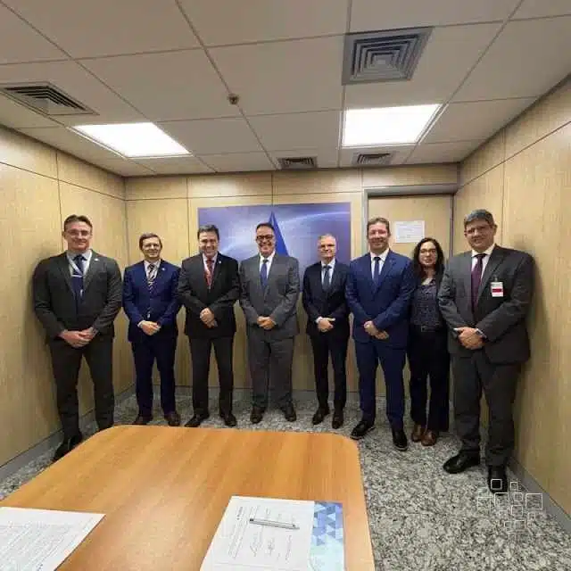 Grupo de pessoas em reunião formal no escritório.