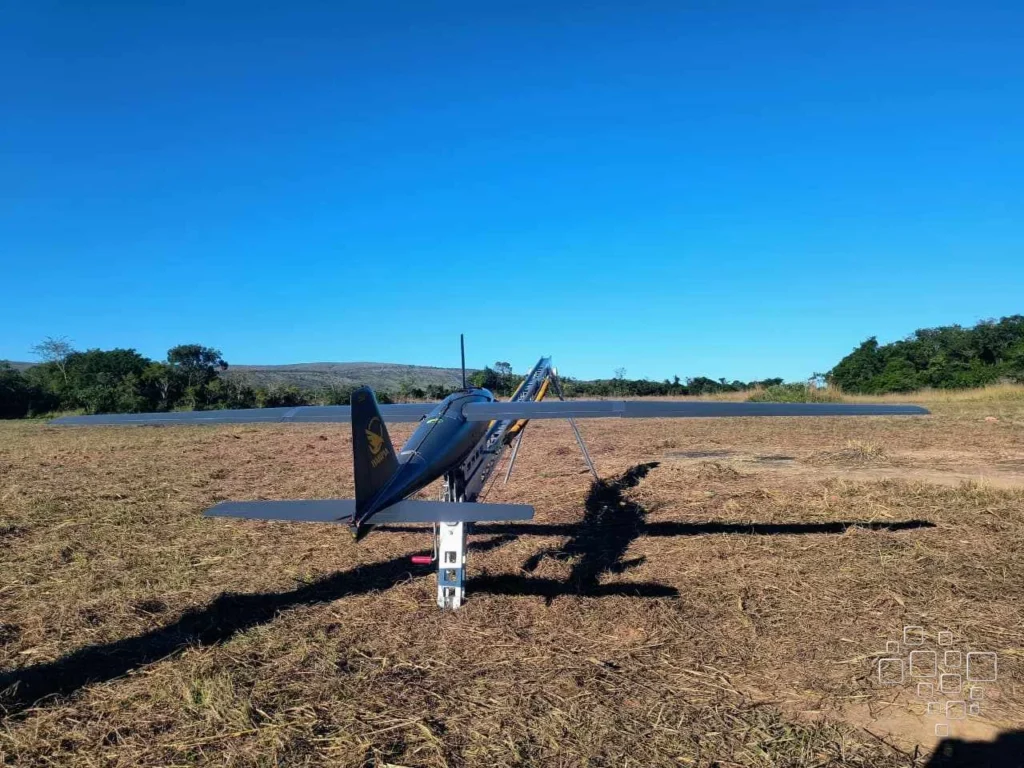 Drone grande em solo rural ensolarado.