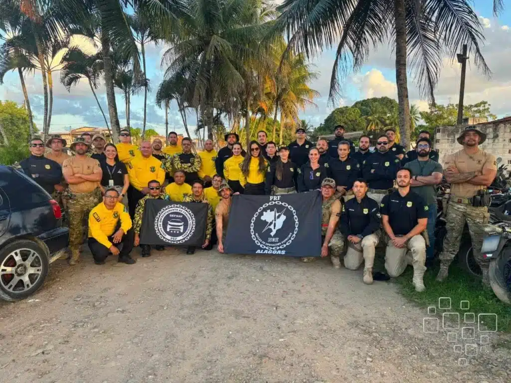 Grupo de pessoas uniformizadas com bandeiras, ao ar livre.