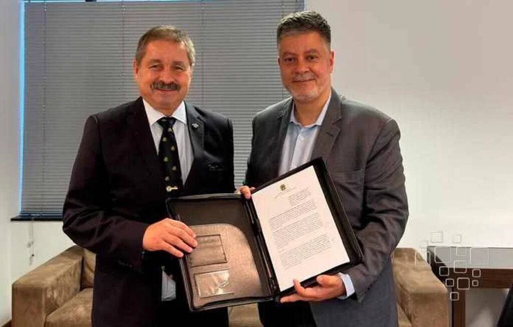 Dois homens em reunião com documento oficial.