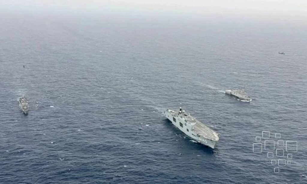 Navios militares navegando no oceano em formação.