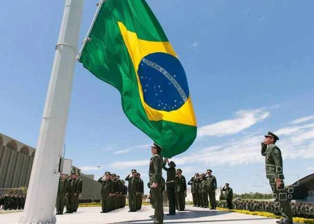 Soldados hasteiam bandeira do Brasil em cerimônia oficial.