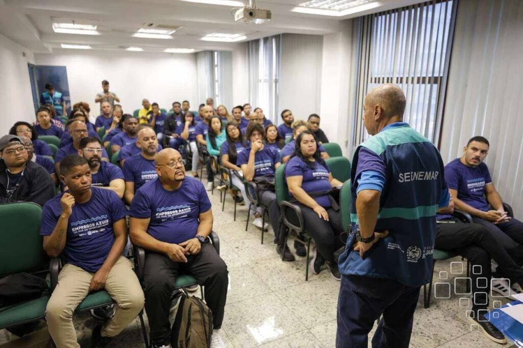 Pessoas em reunião vestindo camisas azuis.