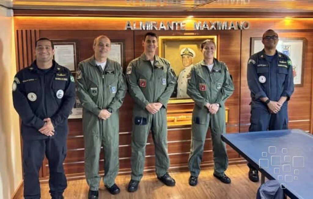 Oficiais posando em frente ao quadro Almirante Maximiano.