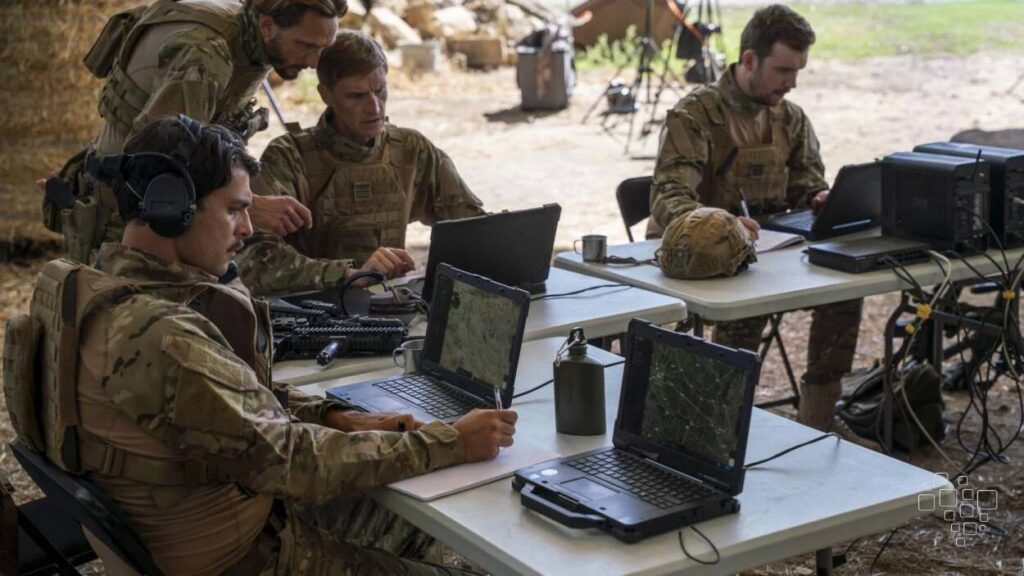 Militares operando laptops em ambiente externo