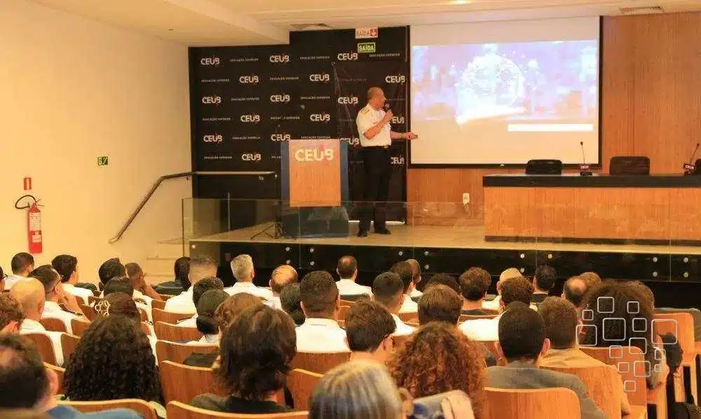 Palestrante apresentando para plateia atenta no auditório.