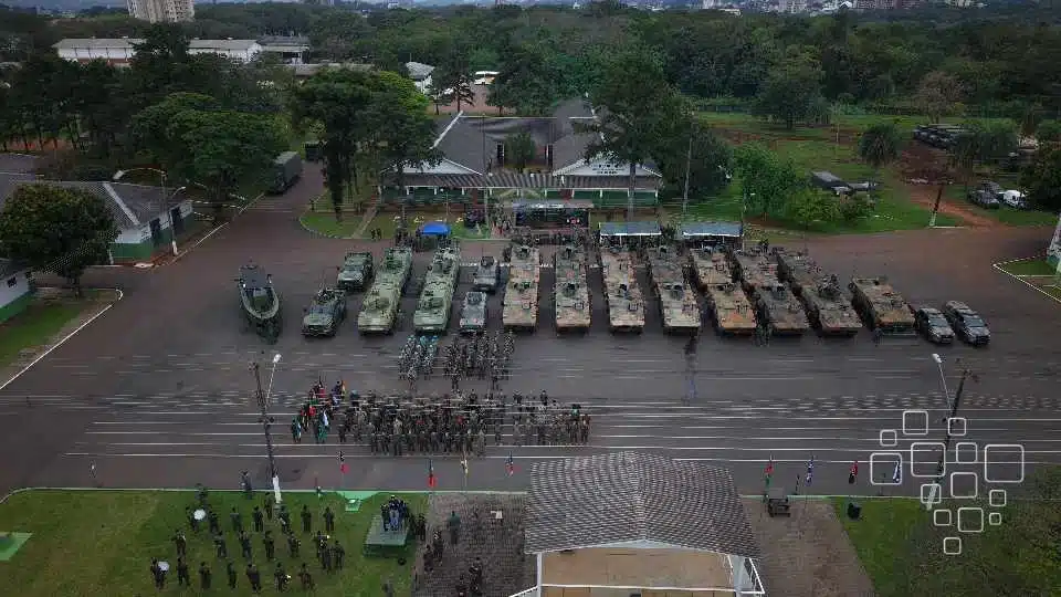 Desfile militar com tanques e soldados em formação.