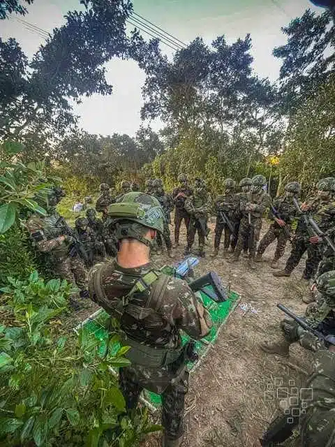 Soldados em treinamento tático na floresta.