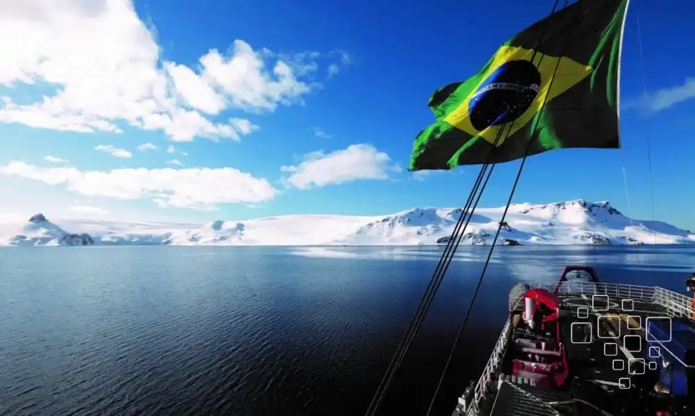 Bandeira do Brasil sobre oceano e montanhas nevadas.