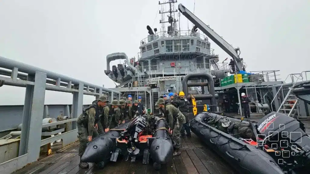 Militares preparam barcos no convés de navio.