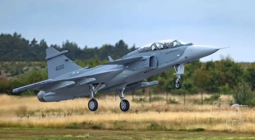 Caça Gripen decolando em campo aberto.