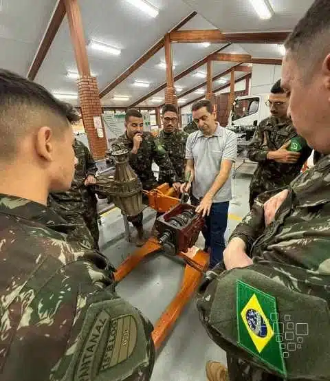 Instrutor ensina montagem de motor a soldados brasileiros.